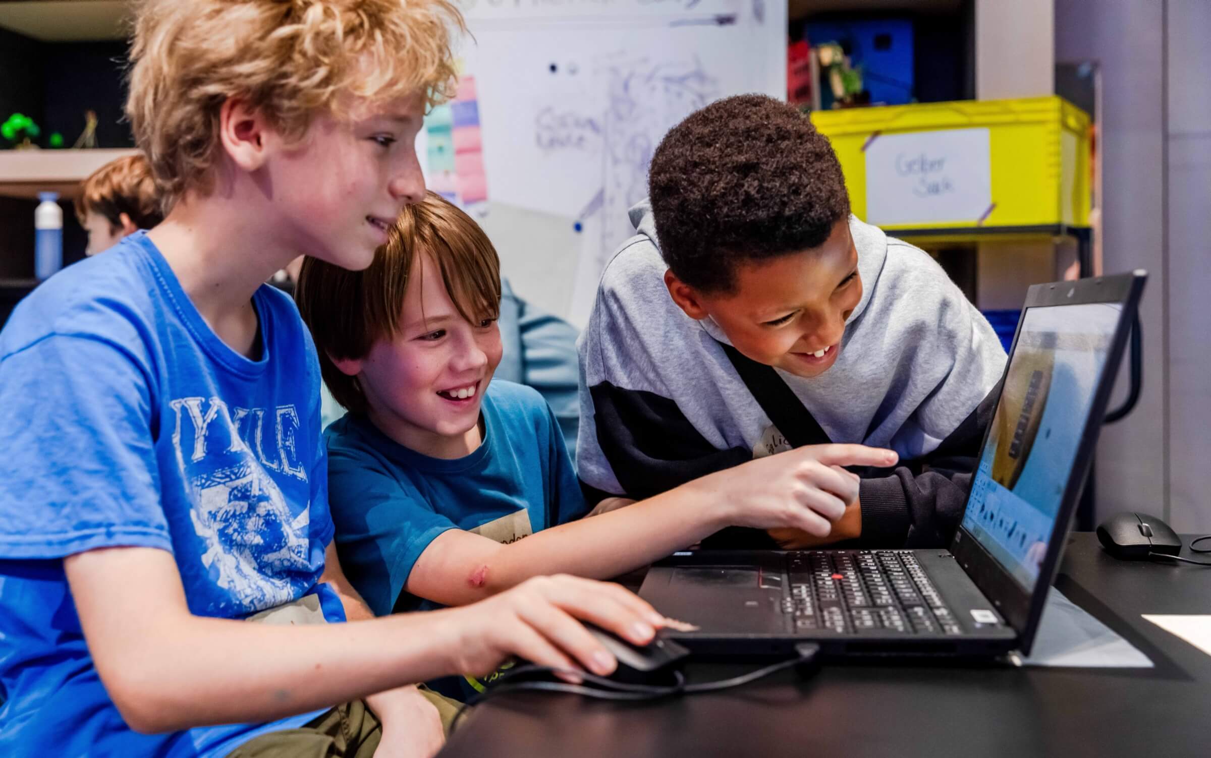 Kinder haben Spaß beim erstellen von 3D Welten in einer Software am Laptop