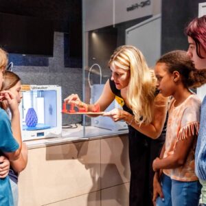 Workshopleiterin Beschreibt Kindern Die Eigenschaften Der 3D Druckmodelle